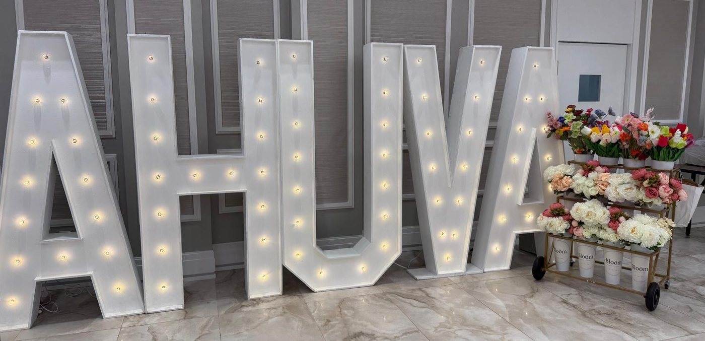 The Bloom cart at an event beside lit marquee letters